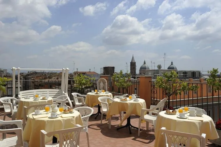 Representative hotel space: A rooftop dining terrace has tables set for meals beneath an open, cloudy sky.