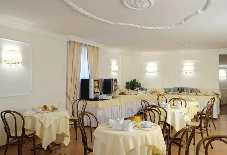 Representative hotel space: A dining room with round tables set with white tablecloths.