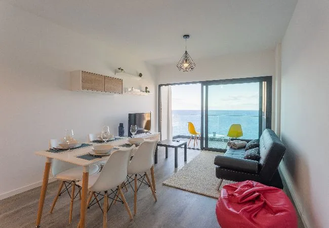 Una zona de comedor y estar se abre a un balcón con vistas al mar.