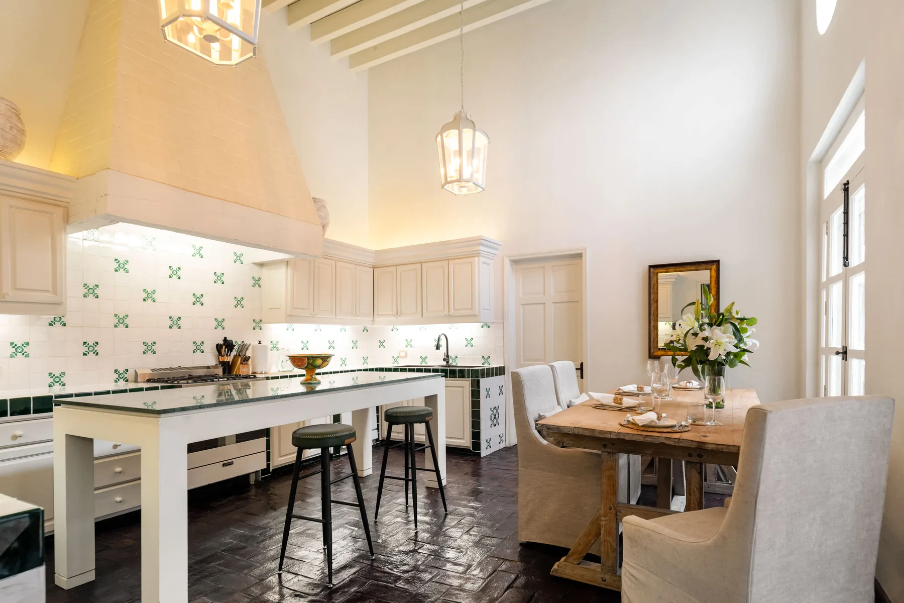 Una luminosa cocina y comedor con una mesa larga y asientos junto a la barra.