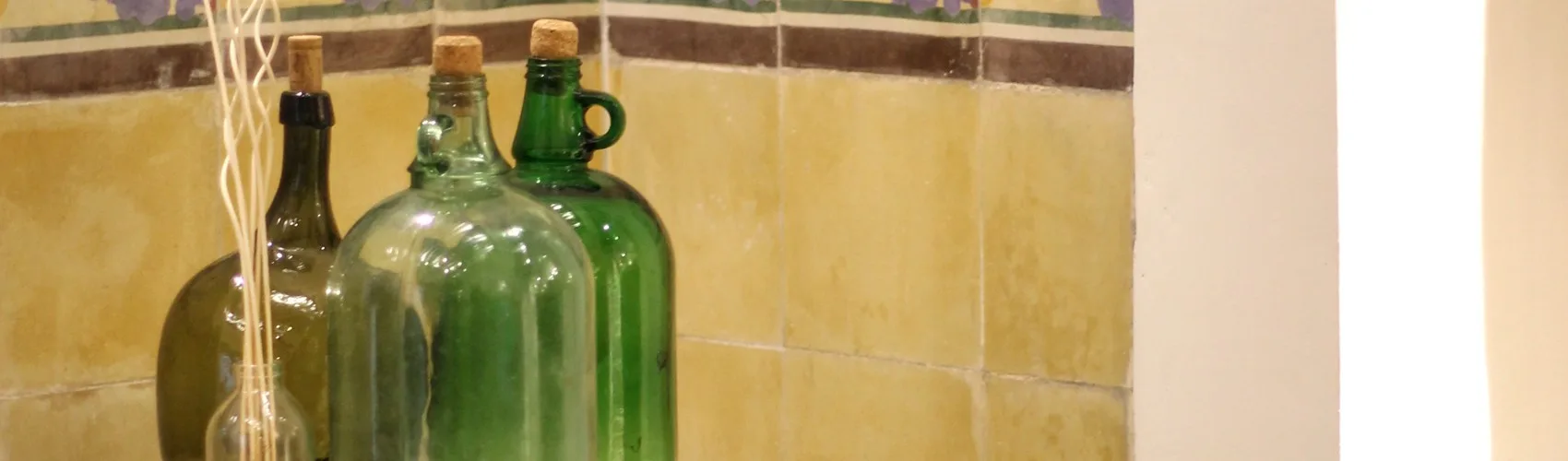 Representative hotel space: A row of green glass bottles sits against a tiled wall.