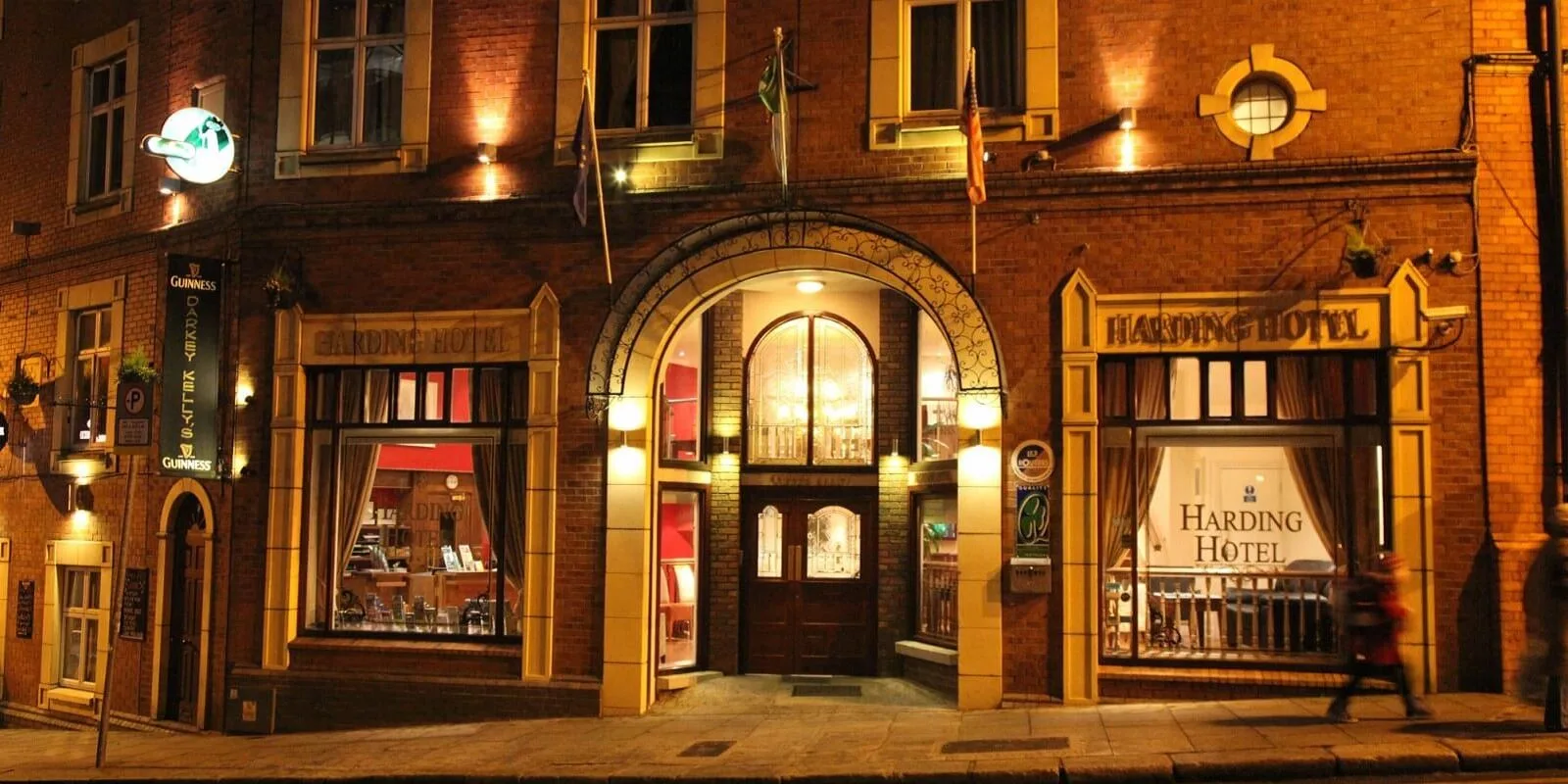 Representative hotel space: A brick hotel entrance at night, with an illuminated arched doorway.