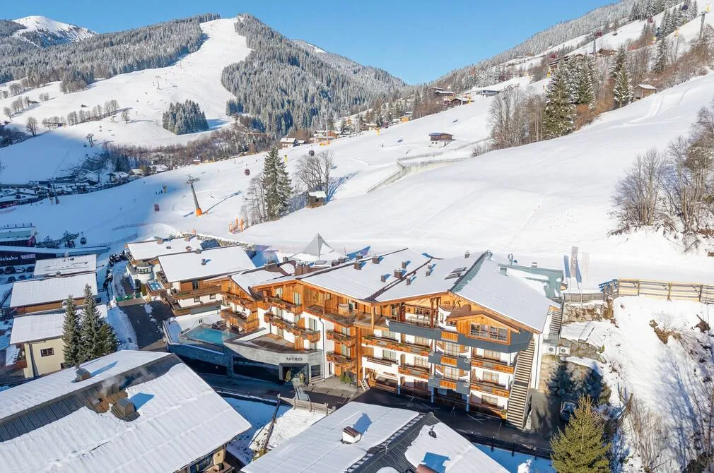 Espacio representativo del hotel: Un complejo alpino nevado con edificios tipo chalet bajo pistas de esquí.