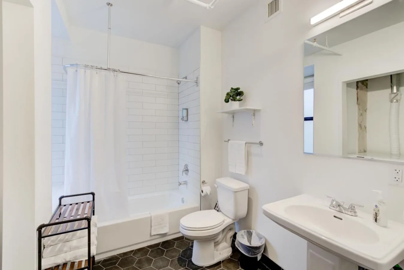 Un baño luminoso con bañera, ducha, inodoro y lavabo.