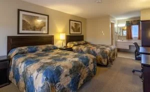Representative hotel space: A hotel bedroom with two beds, framed artwork, and a desk.