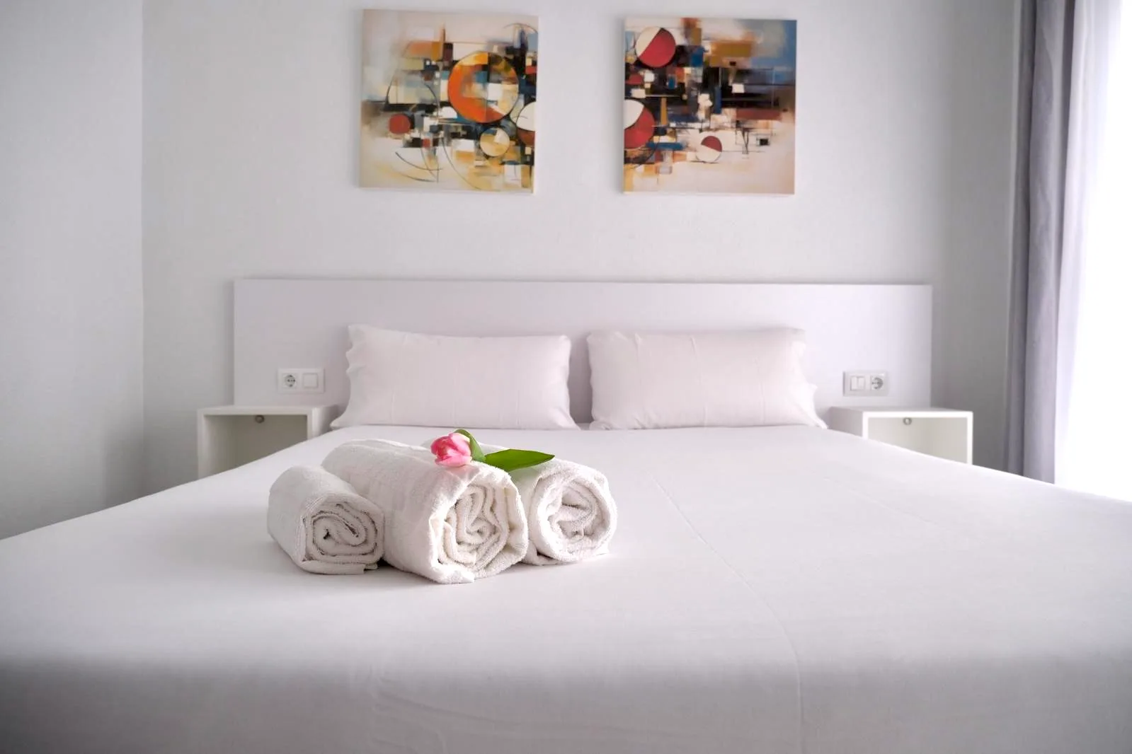 Espacio representativo del hotel: Un dormitorio con una cama bien tendida y toallas dobladas.