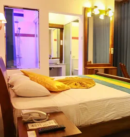Representative hotel space: A bedroom with a made bed beside an open bathroom doorway.