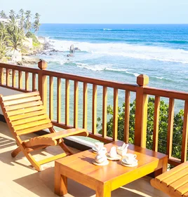 Representative hotel space: A wooden deck overlooks a palm-lined beach and ocean.