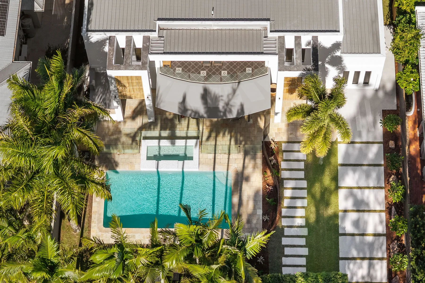 An aerial view shows a swimming pool beside a landscaped courtyard.