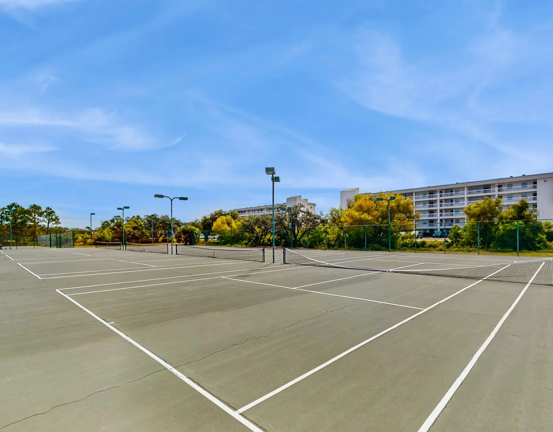 Zona común: Canchas deportivas al aire libre con líneas pintadas y una valla bajo un cielo despejado.
