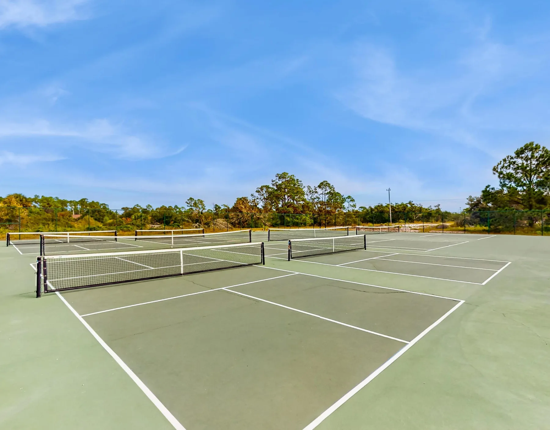 Zona común: Canchas de tenis al aire libre con redes y líneas blancas.