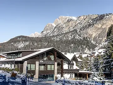 Espacio representativo del hotel: Un edificio hotelero se encuentra bajo una montaña nevada.