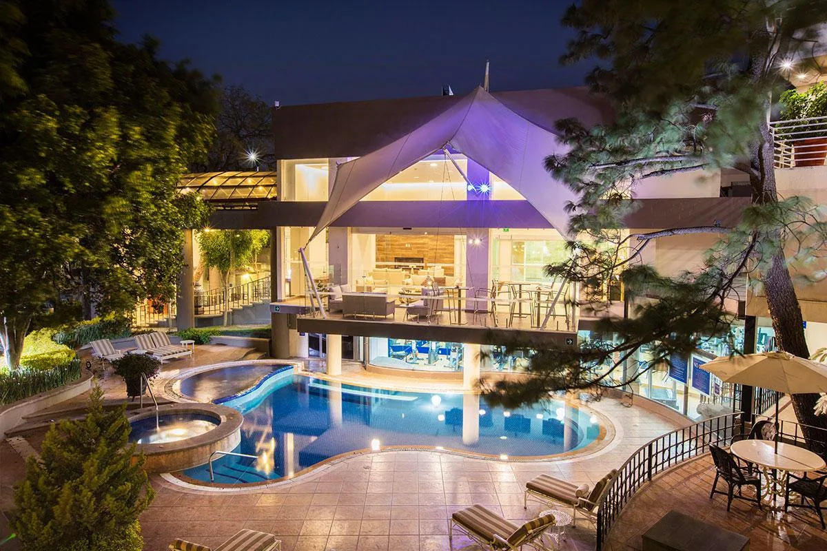 Representative hotel space: A hotel pool courtyard at night, with illuminated water and seating.