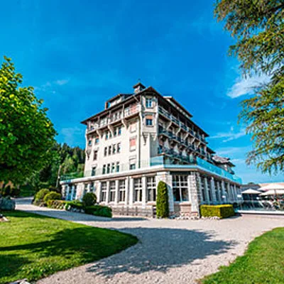 Representative hotel space: A large hotel building stands beside a gravel drive and landscaped grounds.