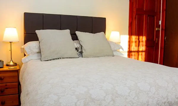 Representative hotel space: A bedroom with a bed dressed in white bedding and two pillows.
