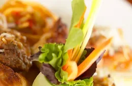 Espacio representativo del hotel: Primer plano de una ensalada fresca con hojas verdes y verduras en rodajas.