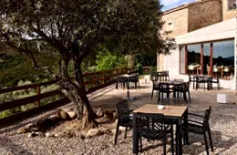Espacio representativo del hotel: Un patio exterior tiene mesas y asientos junto a un edificio.