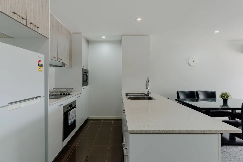 A modern kitchen with a long island and built-in appliances.