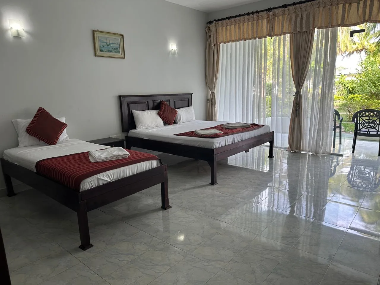 Espacio representativo del hotel: Un dormitorio con dos camas y puertas de vidrio que dan a un patio.