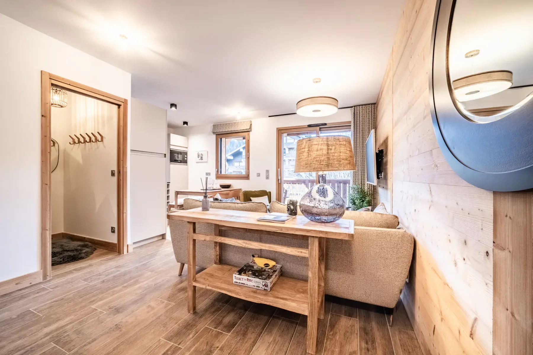 A bright living and dining area with a wooden table and seating.