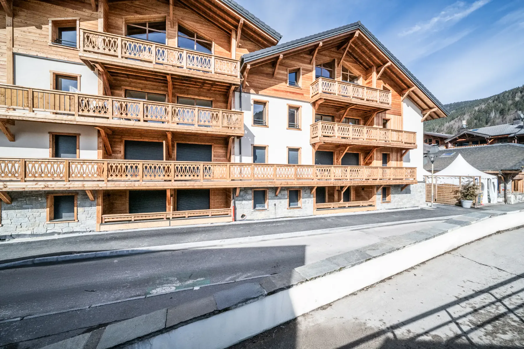 Shared amenity: A multi-story building with wooden balconies stands beside a road.
