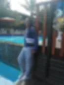 Espacio representativo del hotel: Una escena junto a la piscina muestra a una persona de pie al lado del agua.