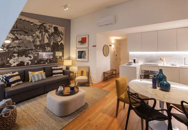 Una sala de estar y cocina de concepto abierto con sofá y mesa de comedor.