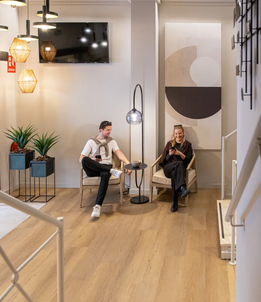 Espacio representativo del hotel: Un salón de hotel con asientos, lámparas colgantes y arte abstracto enmarcado.