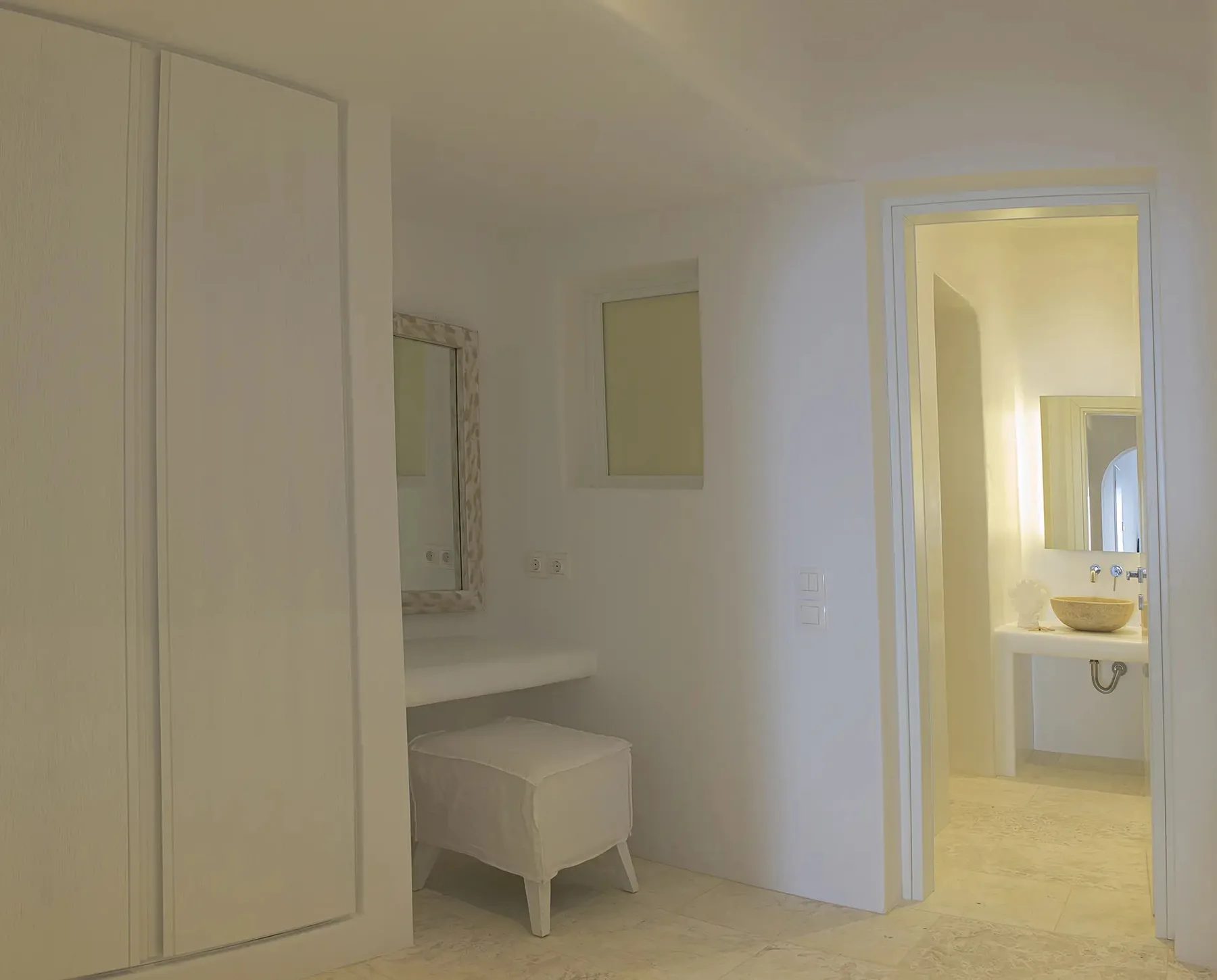 A bright interior passage opens into a bathroom with a sink and mirror.