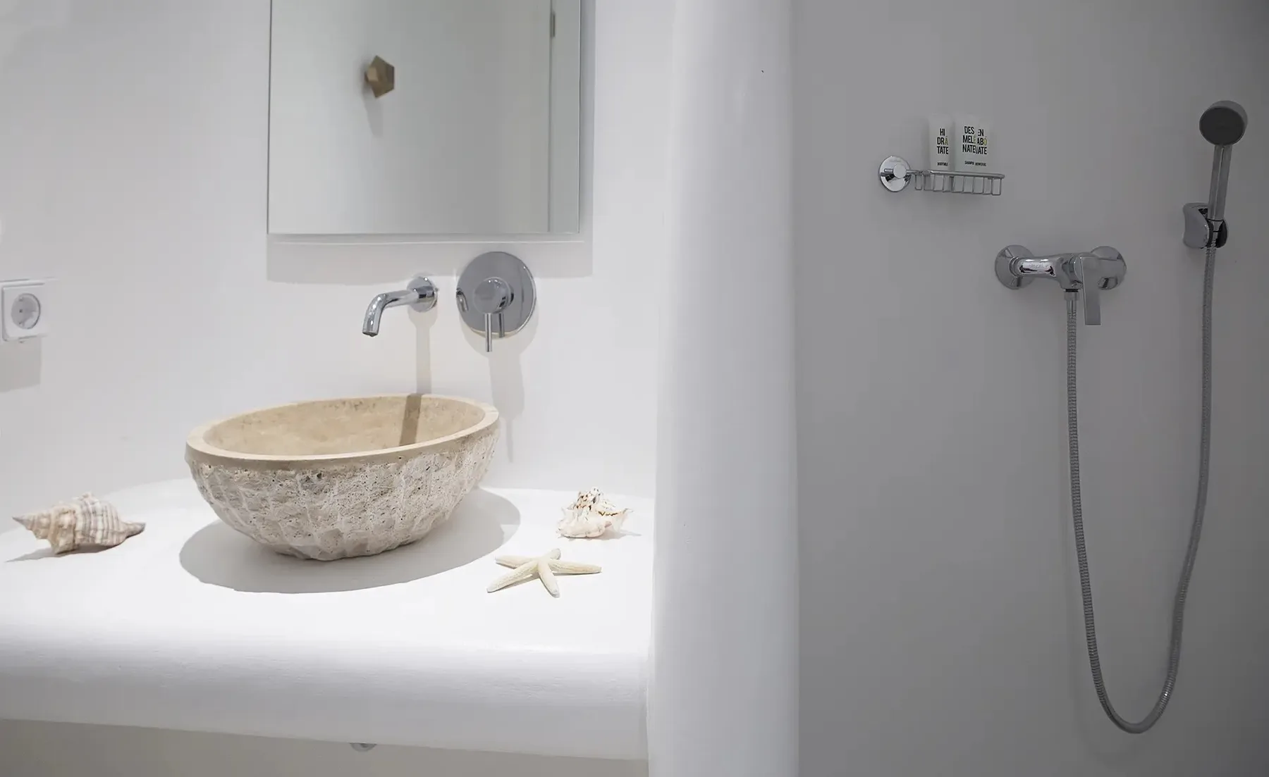 A bathroom vanity with a vessel sink sits beside a wall-mounted shower.