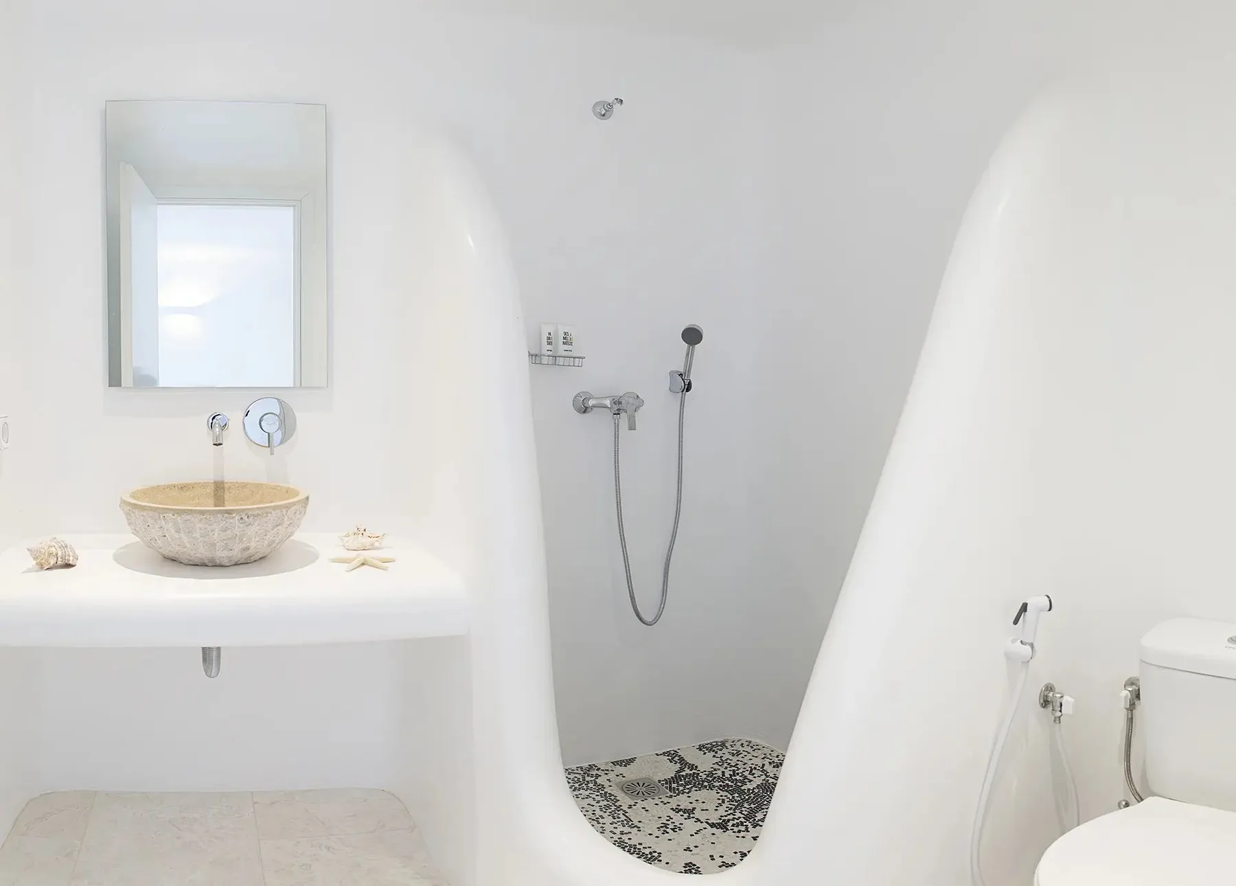A bright bathroom with a vessel sink and an open shower area.