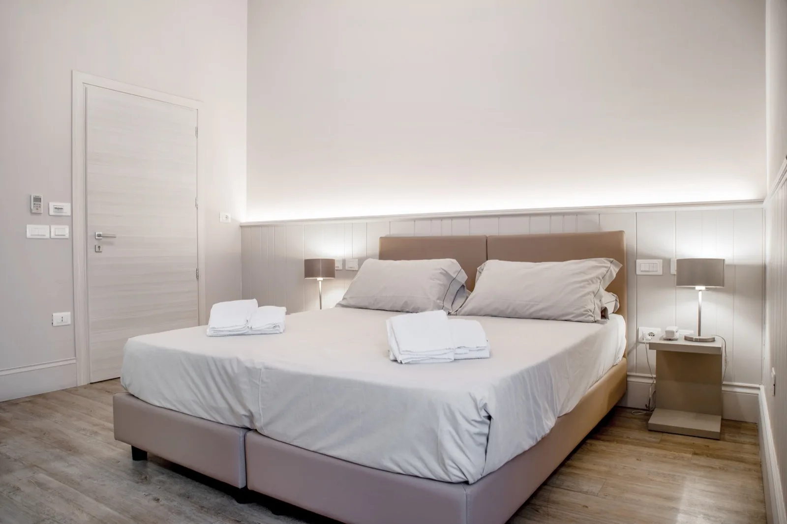 Representative hotel space: A bedroom with a large bed, bedside tables, and folded towels.