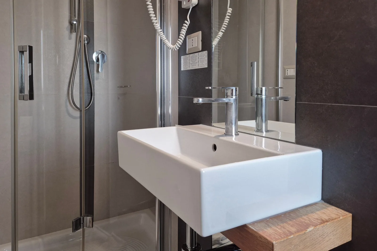 Representative hotel space: A bathroom with a wall-mounted sink and shower.