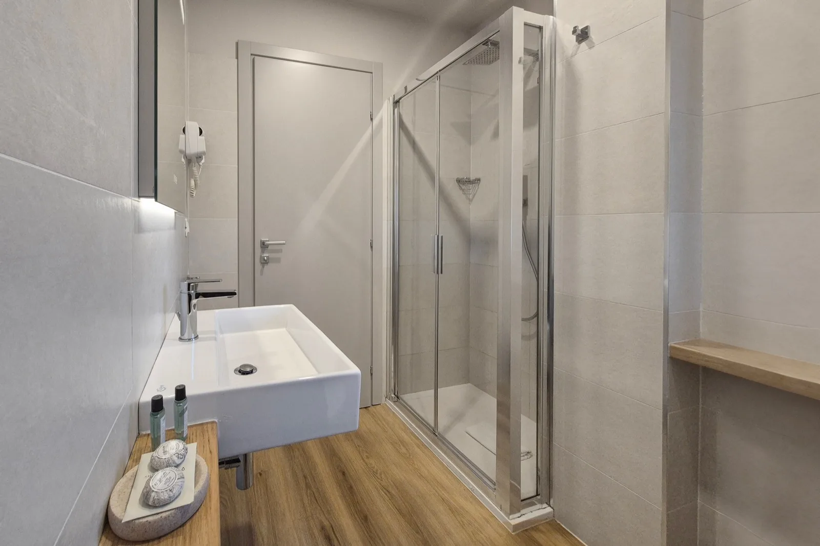 Representative hotel space: A modern bathroom with a sink and glass shower.
