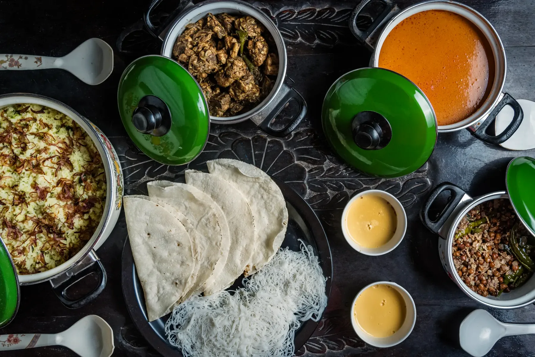 An overhead view of a meal with rice, flatbread, and several dishes.