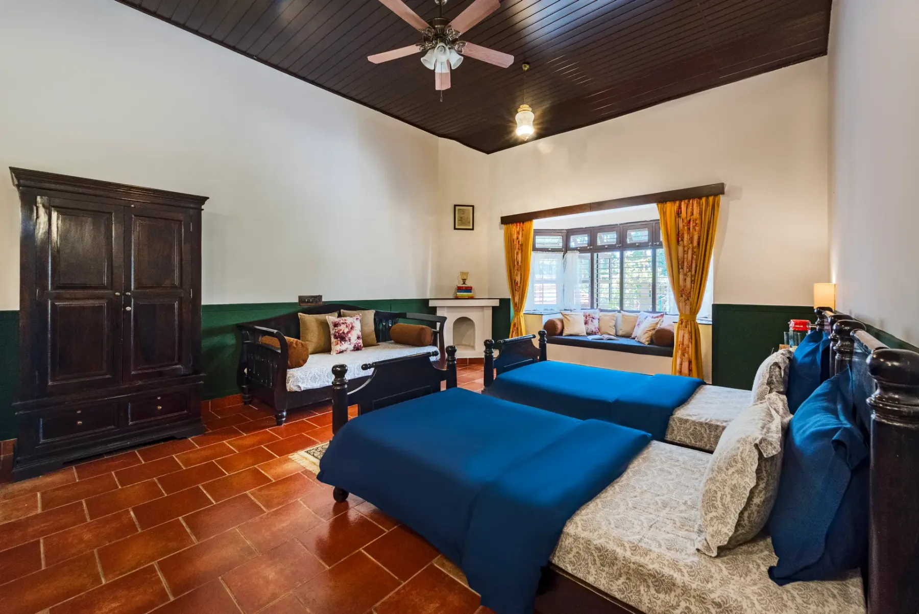 A bedroom with a large bed, dark wooden furniture, and a window with curtains.