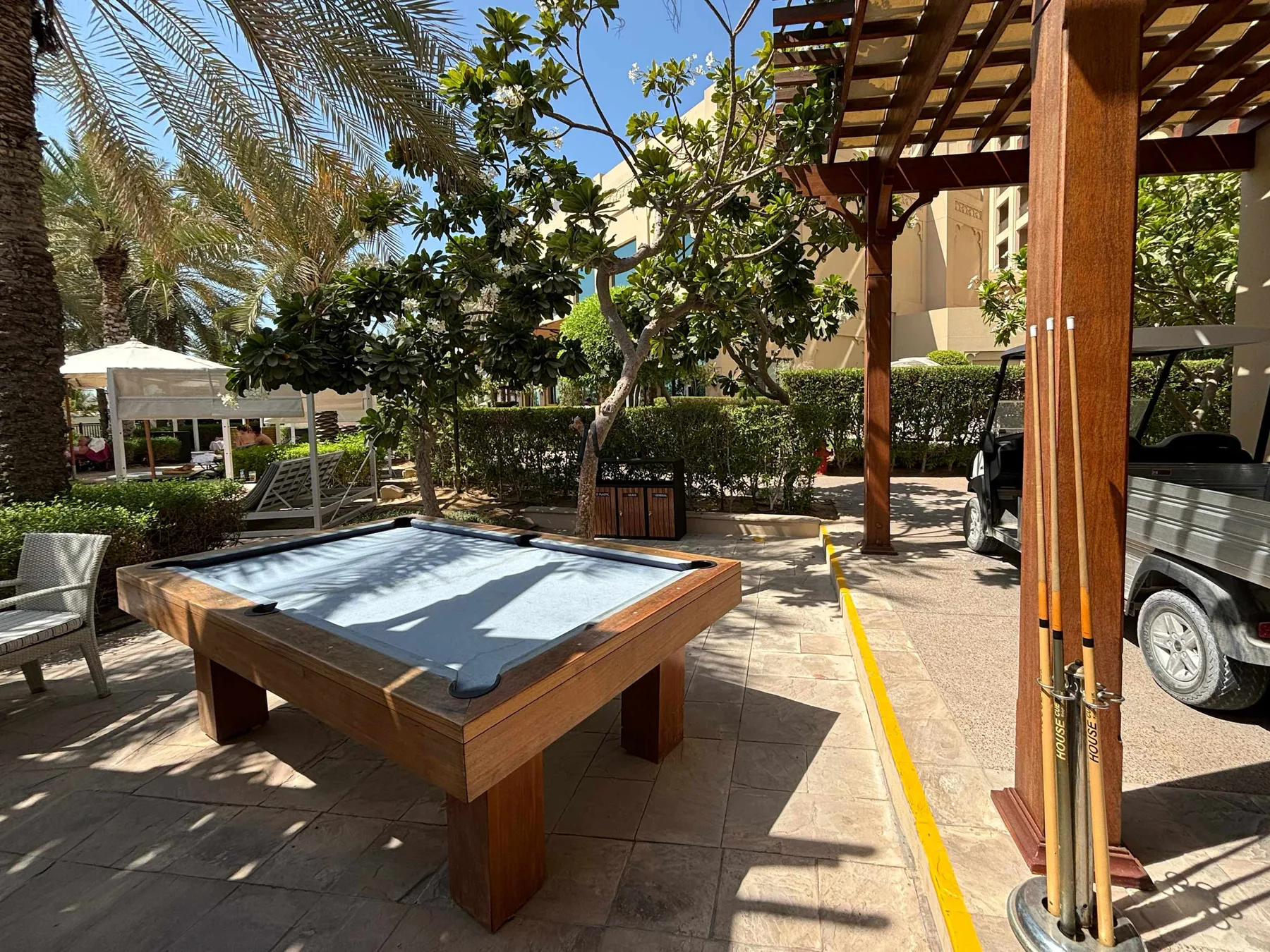 Shared amenity: An outdoor recreation area with a pool table beneath a wooden pergola.