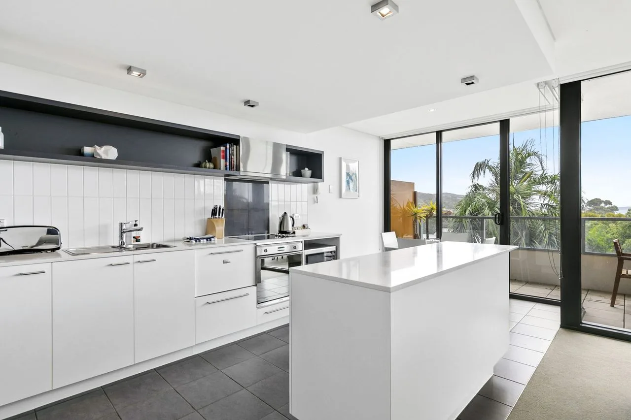Una cocina moderna y luminosa con gabinetes blancos e isla central.
