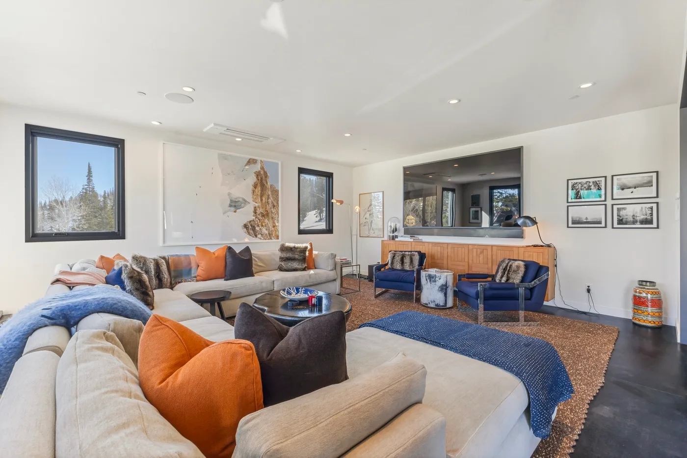 A bright living room with seating around a low table and a blue rug.
