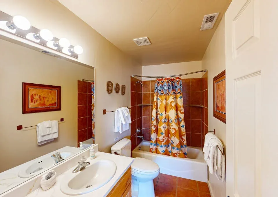 Un baño con bañera, cortina de ducha colorida y lavabo.