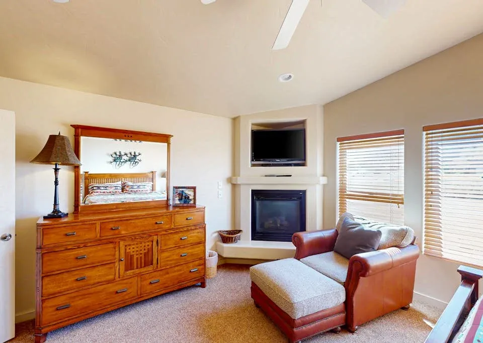 Una sala de estar con chimenea, televisor y asientos.