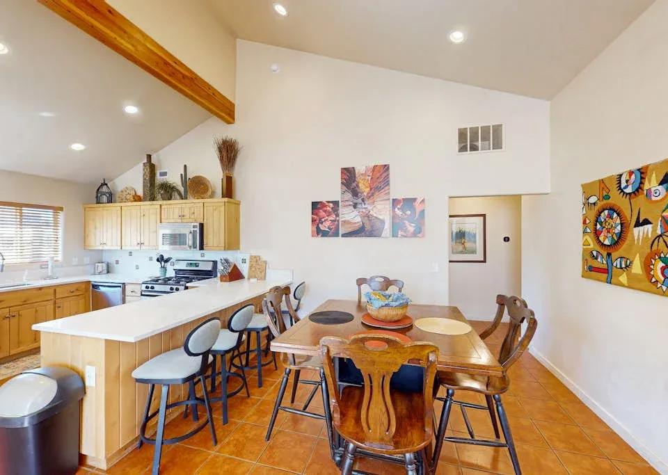 Una luminosa cocina y comedor con una isla grande y una mesa de madera.