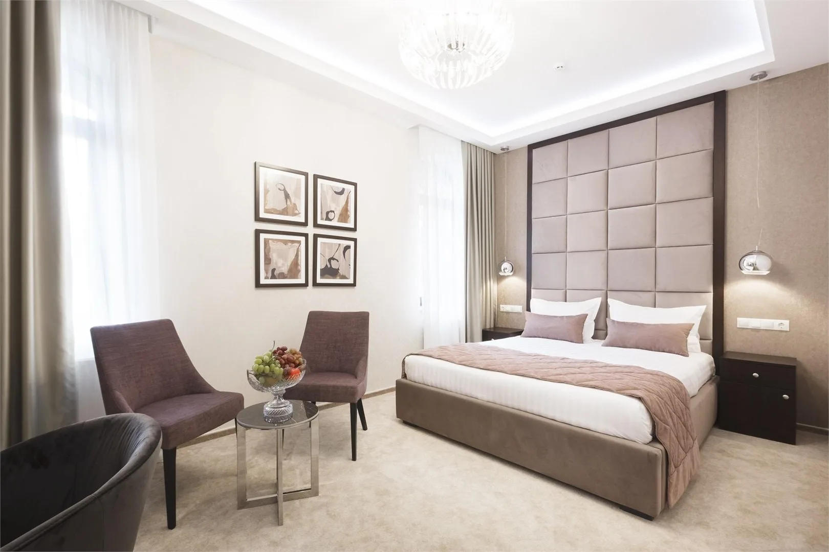 Espacio representativo del hotel: Dormitorio con cama, cabecero tapizado y zona de estar.