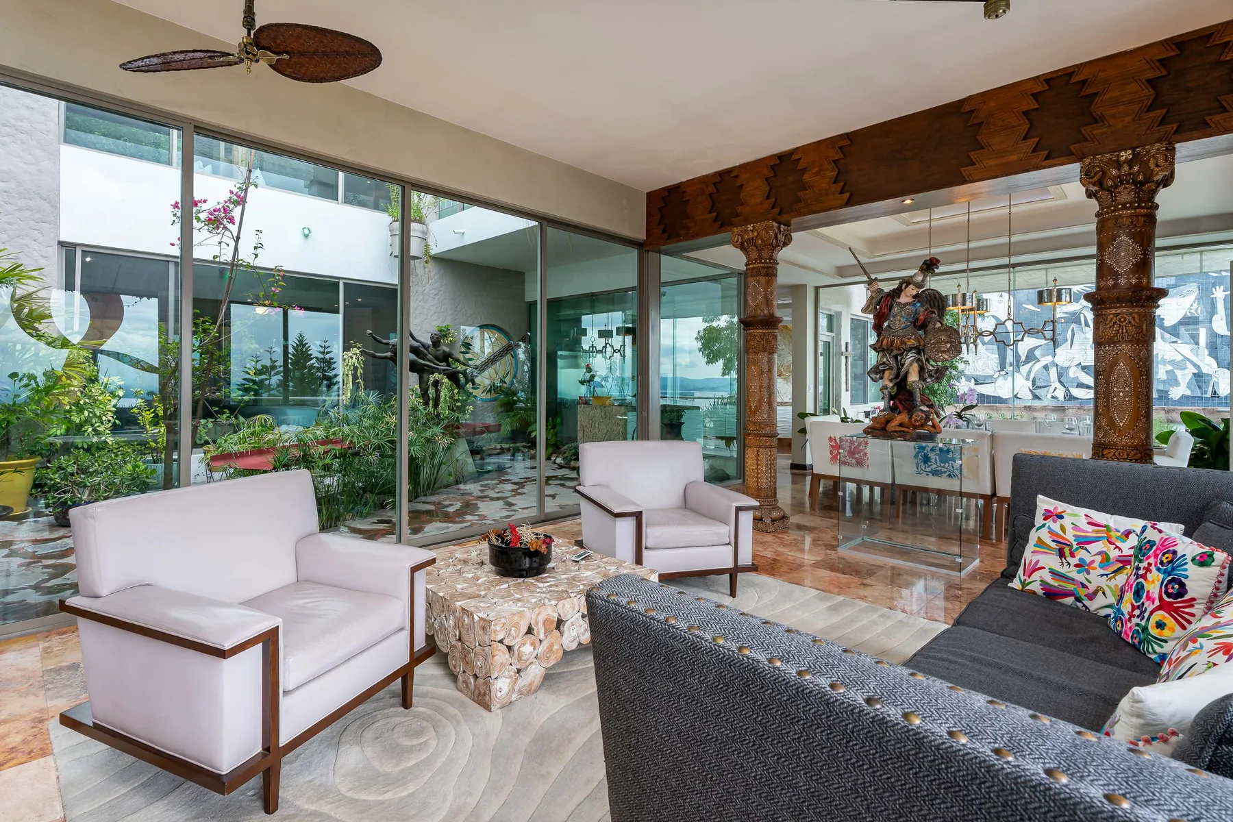 A living room with seating, glass walls, and a decorative wooden arch.