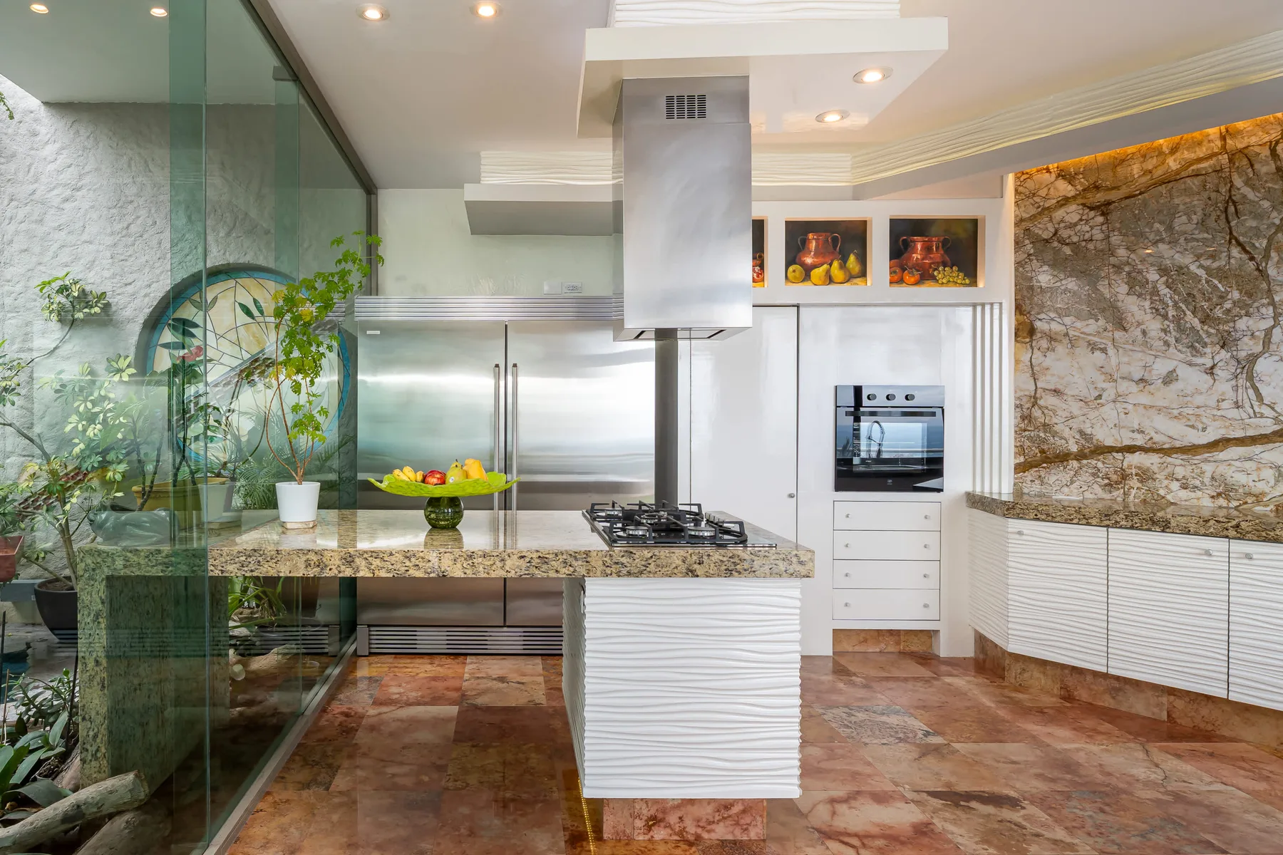 A modern kitchen with a central island and stainless steel appliances.