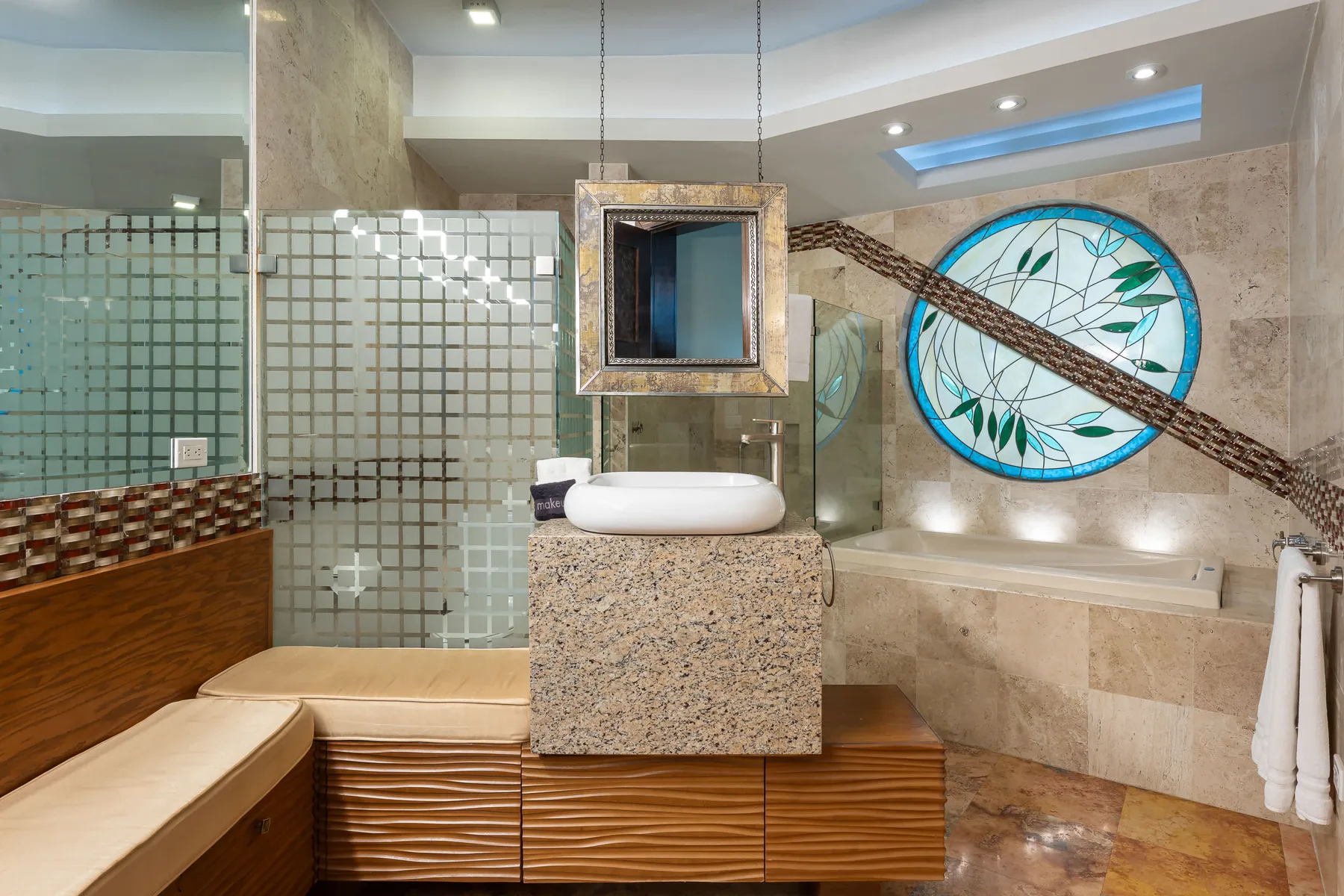 A bathroom with a freestanding tub, glass partitions, and a round decorative window.