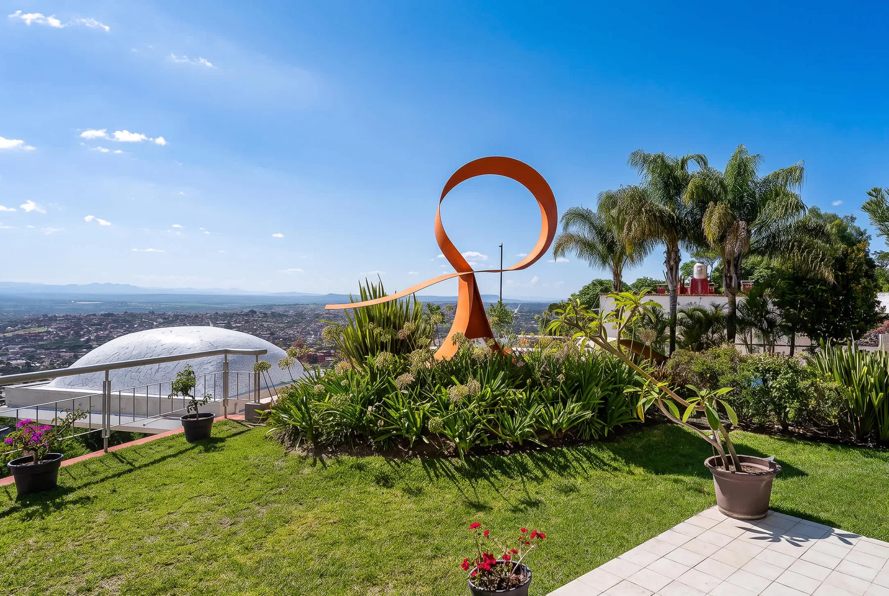 Shared amenity: A landscaped garden with a large abstract sculpture and distant city views.
