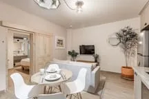 A bright dining and living area with a round table and seating.