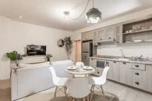 A bright kitchen and dining area with white cabinetry and a table.