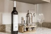A kitchen counter displays a wine bottle, glasses, and a small serving tray.